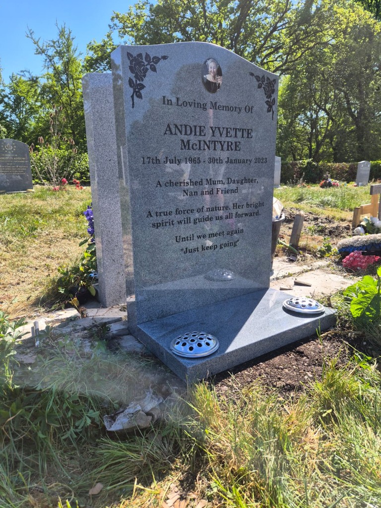Polished grey speckled granite ogee-top headstone with etched roses, ceramic portrait oval and matching base with flower vase inserts at City of London Cemetery, East London — memorial installation