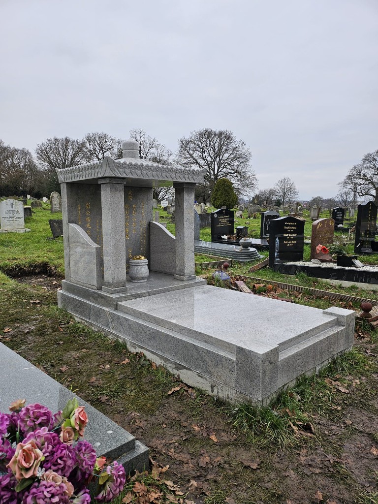 Polished light grey granite memorial with pagoda-style roof, four supporting pillars, gold Chinese characters on the rear wall, matching urn and full-length grave base at Hendon Cemetery and Crematorium, North London — memorial installation