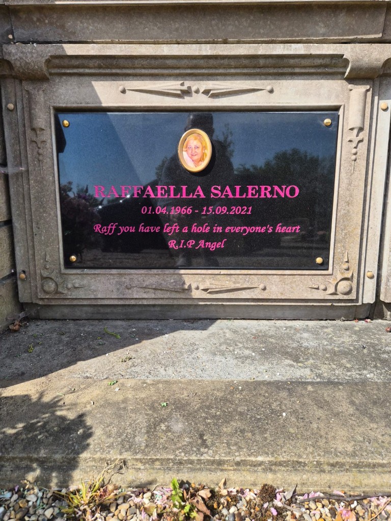 Black granite kerb memorial plaque with pink lettering, corner fixings and ceramic portrait insert at St Pancras and Islington Cemetery, North London, memorial plaque installation