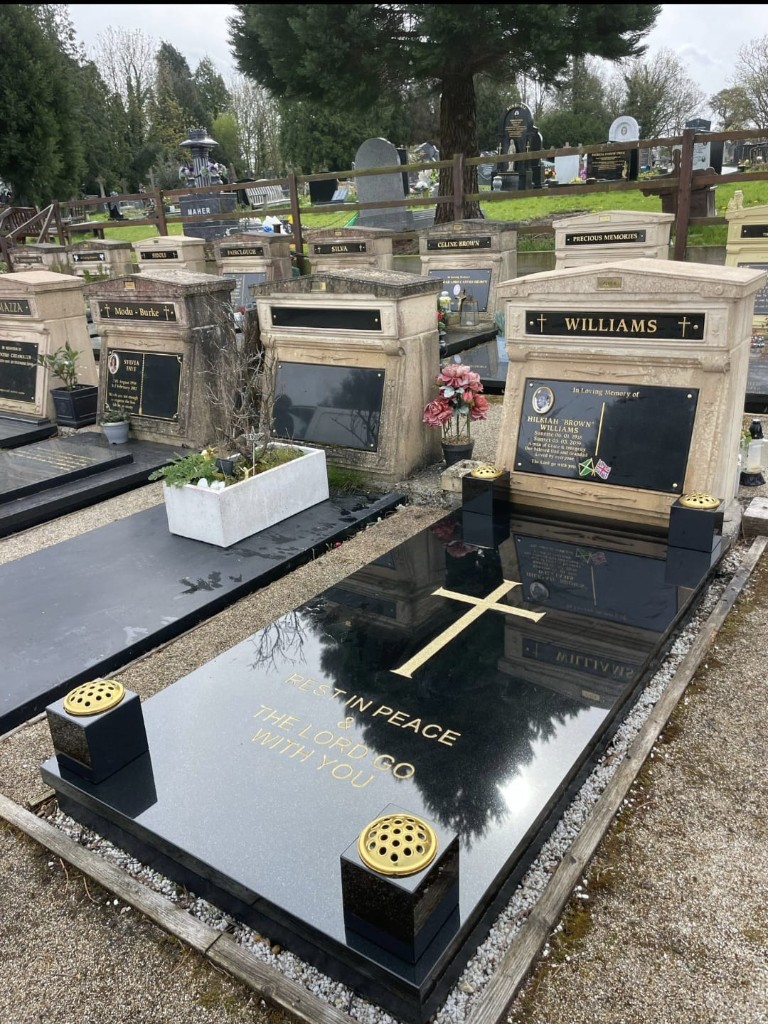 Polished black granite ledger memorial with gold cross and inscription at St Pancras Cemetery, North London — memorial installation