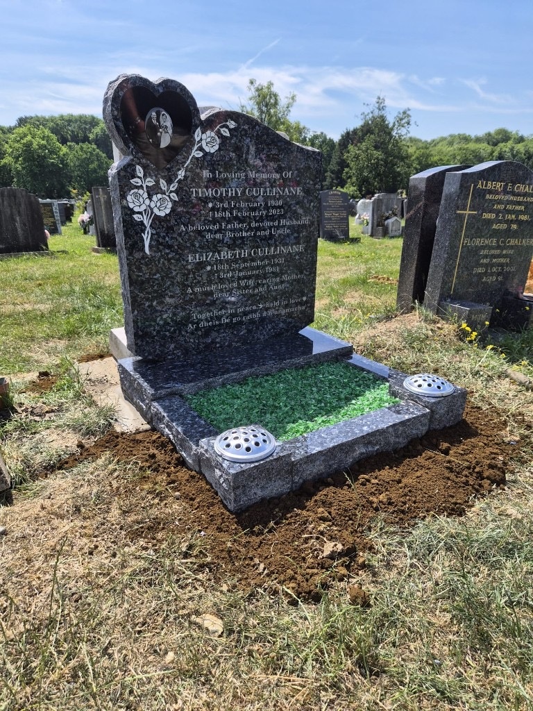 Polished blue pearl granite full kerb memorial with heart-shaped portrait inset, etched rose design and green glass chippings at St Pancras and Islington Cemetery, North London — memorial installation